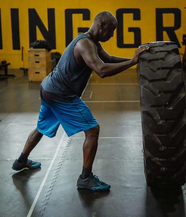 Athletic man performing functional strength training in dark gym